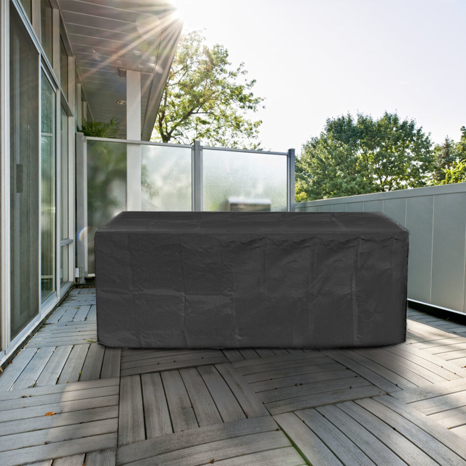 Large black 210D Waterproof Outdoor Furniture Cover made of Oxford cloth on a balcony, labeled as waterproof, anti-UV, windproof, and snow resistant, with an inset showing the cover in use and its storage bag.