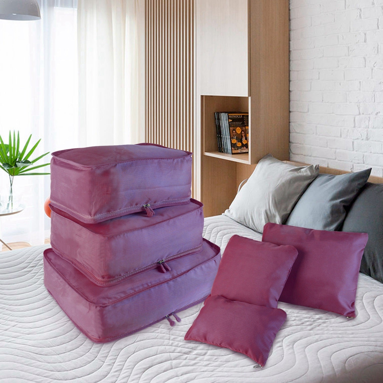 Set of four 9Pcs Clothes Storage Bags Water-Resistant Travel Luggage Organizer Clothing Packing Cubes of varying sizes with clothing items, displayed next to a folded floral blouse, all on a white background.