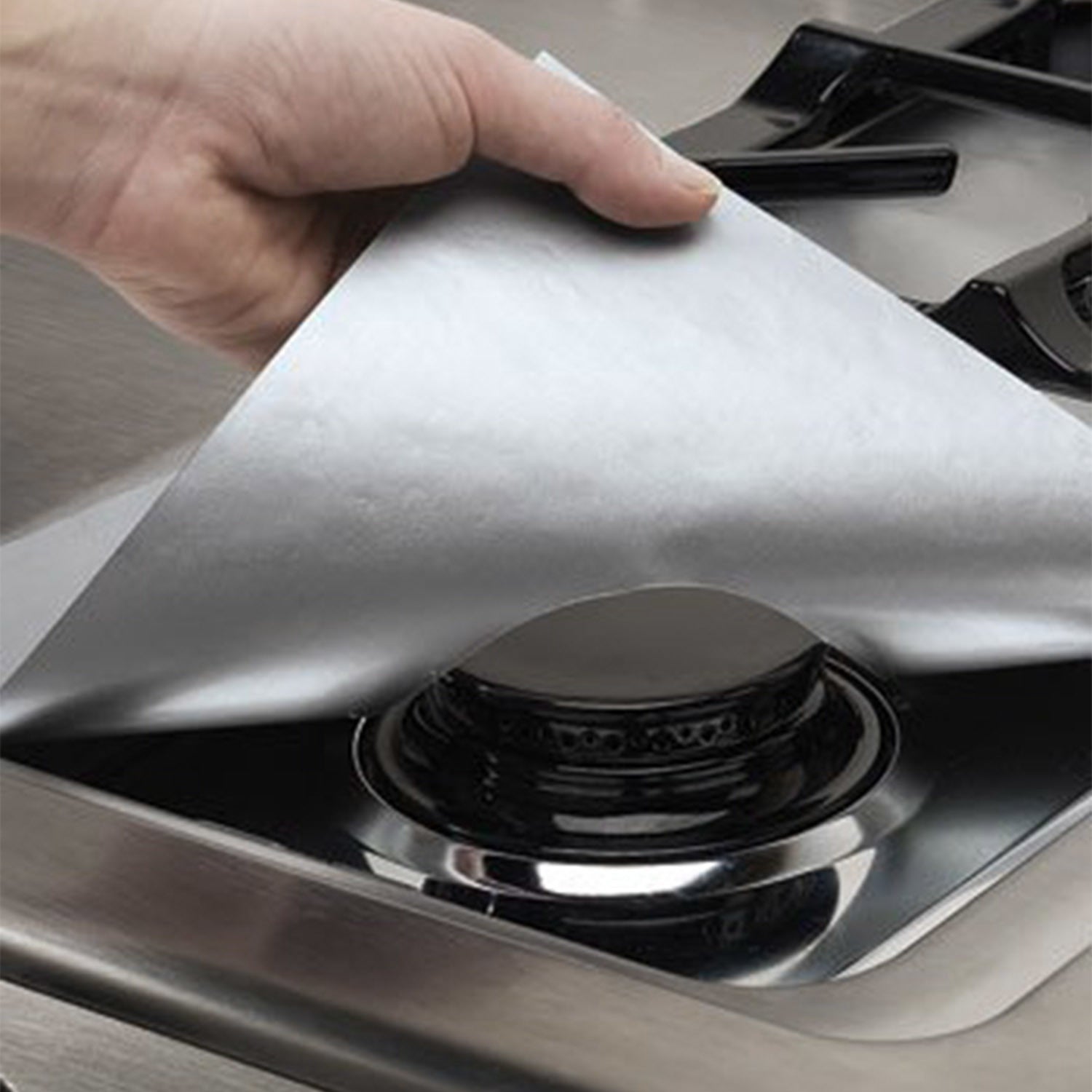 A stack of 4-Pack Reusable Nonstick Stovetop Burner Protector Liner papers with a white circle and crossing lines symbol in the center of the top sheet, treated with a PTFE coating.