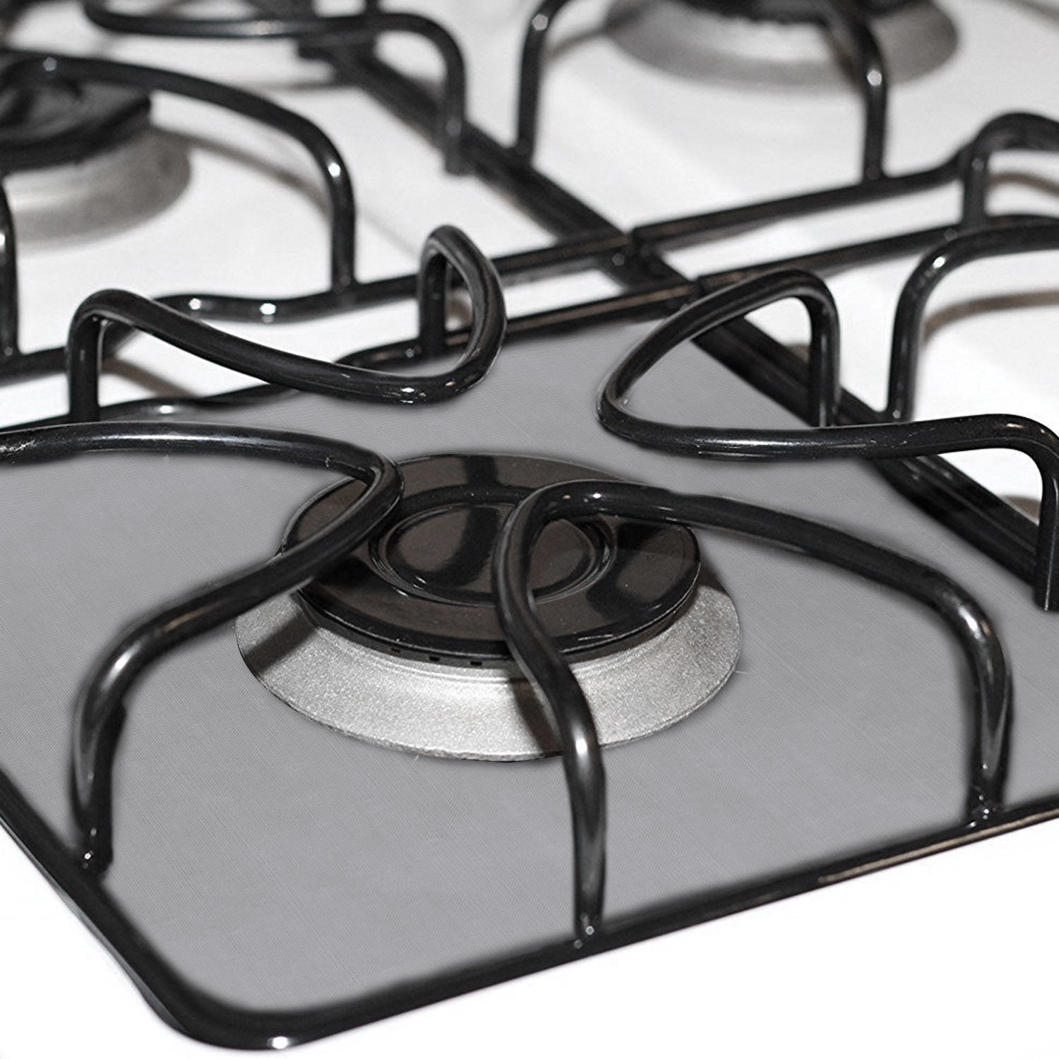 A stack of 4-Pack Reusable Nonstick Stovetop Burner Protector Liner papers with a white circle and crossing lines symbol in the center of the top sheet, treated with a PTFE coating.