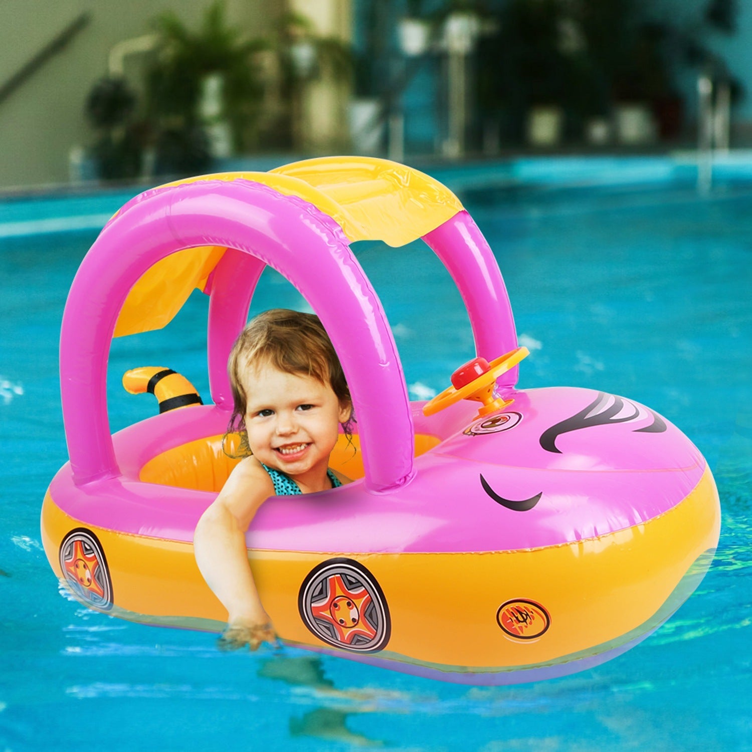 A young child smiles while sitting in a colorful Baby Inflatable Pool Float Car Shaped Toddler Swimming Float Boat Pool Toy Infant Swim Ring Pool with Sun Protection Canopy for 1-3 Year-Old Kids Infant Toddlers in a swimming pool.