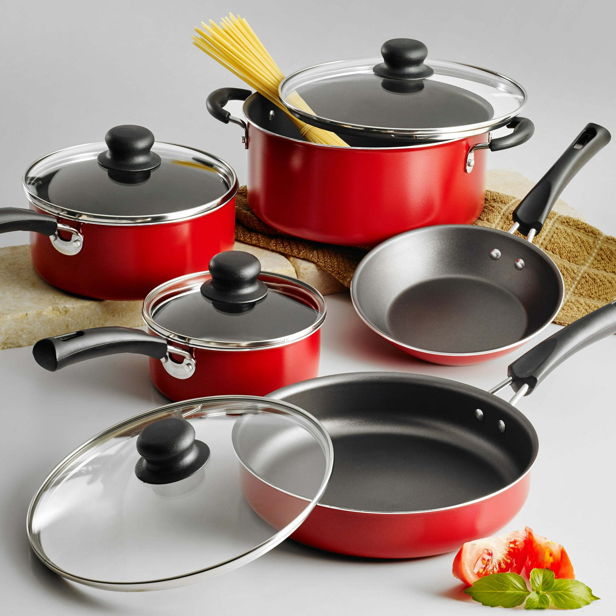 A set of new 9-Piece Non-Stick Cookware Set including two pots, a saucepan, and two frying pans, all with tempered glass lids and black handles, arranged on a white background.