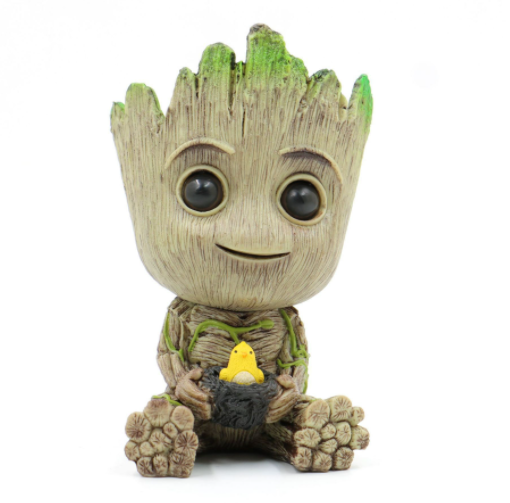A Guardians of the Galaxy Groot Tree Man Hand Ornament, crafted from PVC, holding a small bird, with green leaves sprouting from its head, isolated on a white background.