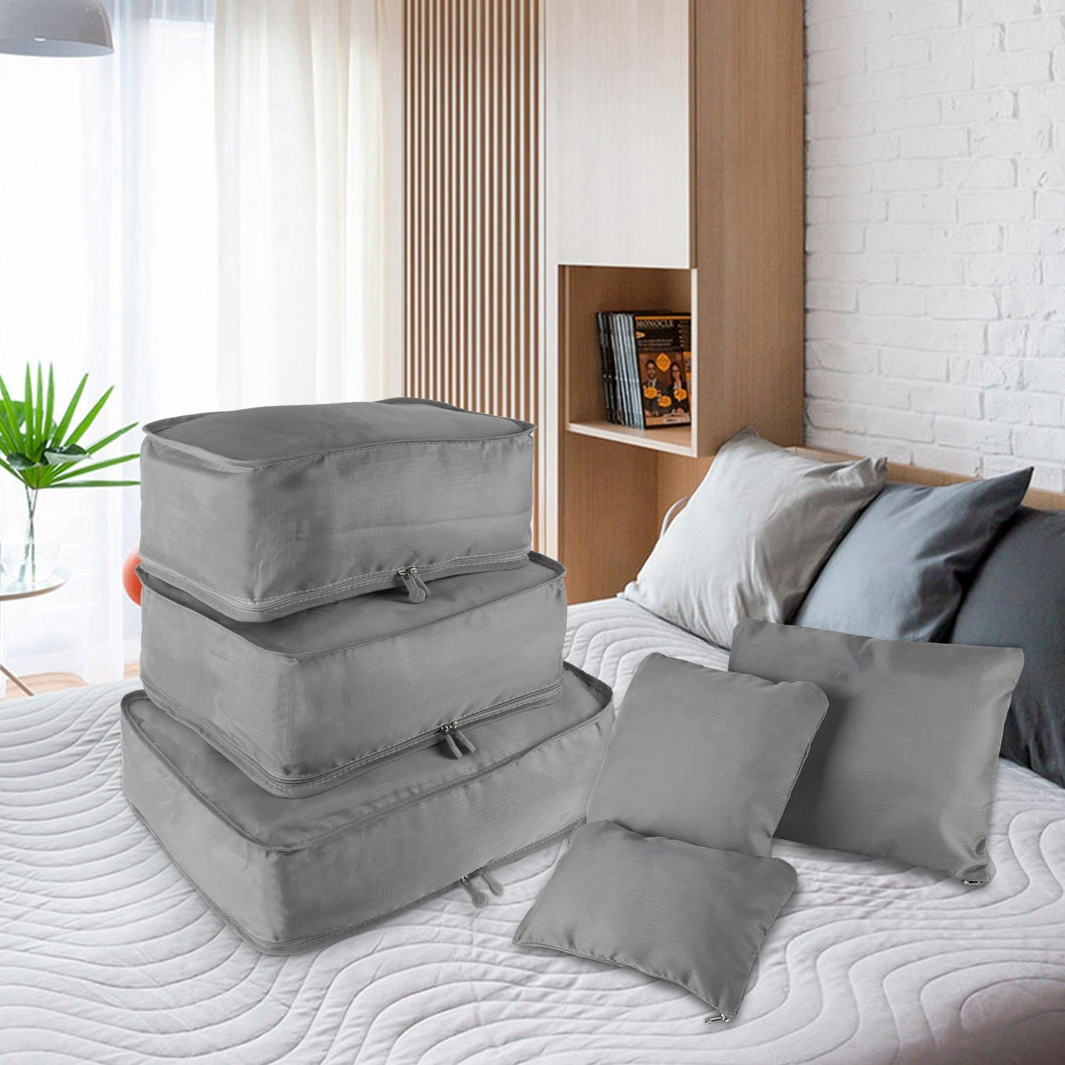 Set of four 9Pcs Clothes Storage Bags Water-Resistant Travel Luggage Organizer Clothing Packing Cubes of varying sizes with clothing items, displayed next to a folded floral blouse, all on a white background.