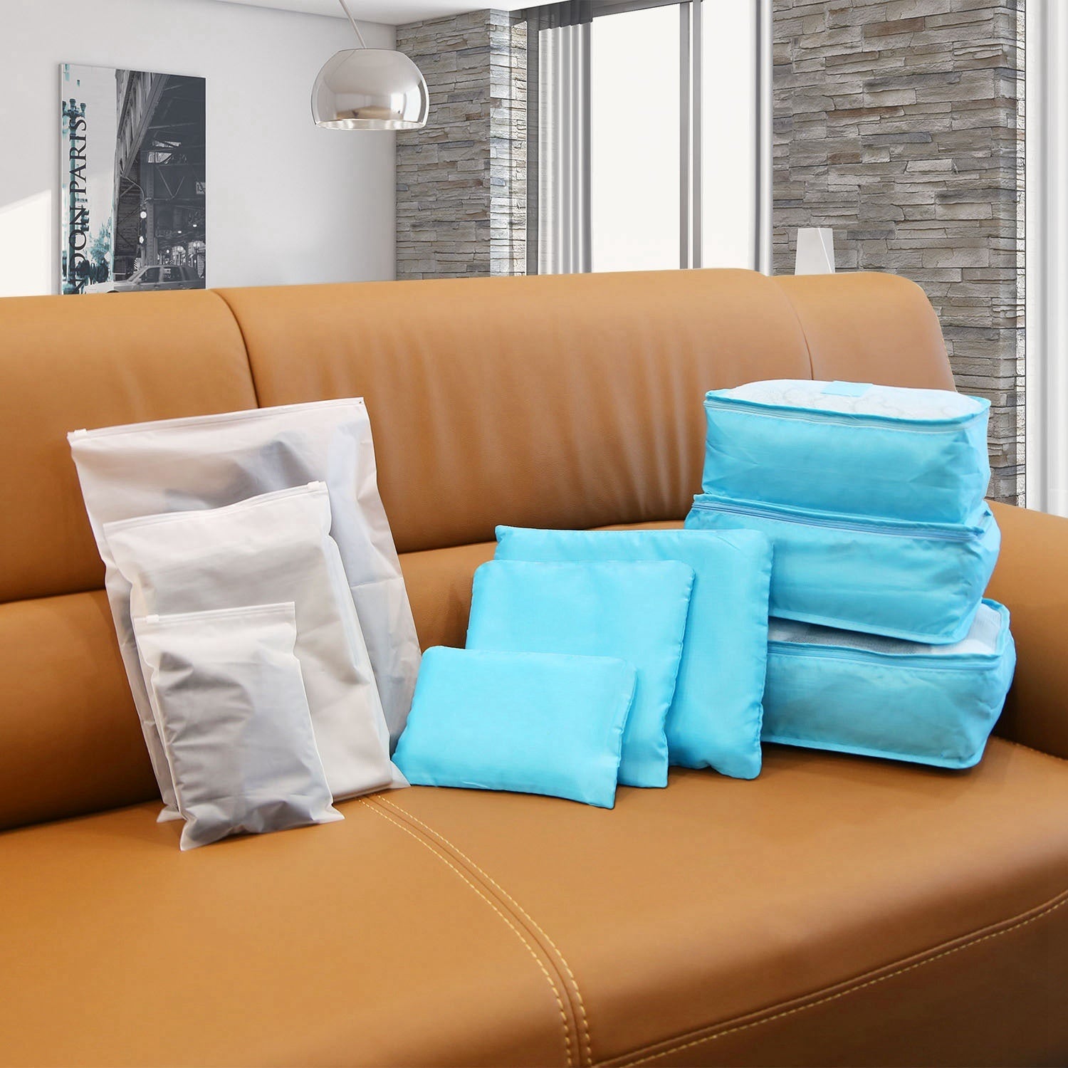 Set of four 9Pcs Clothes Storage Bags Water-Resistant Travel Luggage Organizer Clothing Packing Cubes of varying sizes with clothing items, displayed next to a folded floral blouse, all on a white background.