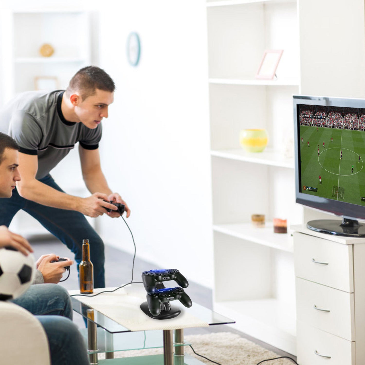 Two men play video games in a living room, sitting on a couch with a bottle and controllers; in the foreground, a Charging Dock Station Dual Micro USB Charger Stand For PS4 Pro/PS4 Slim Gamepad Controller Handle Charging Station with an LED light indicator and technical feature icons.
