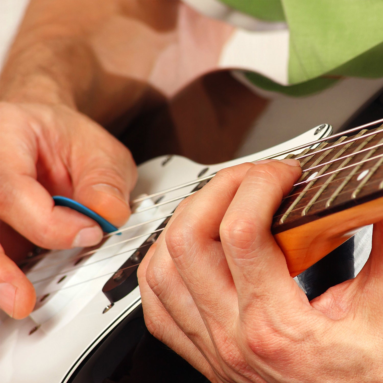 A circular arrangement of Standard Acoustic Electric Plectrums Guitar Picks 12-Pack in red, purple, green, yellow, and blue, creating a symmetrical pattern on a white background.