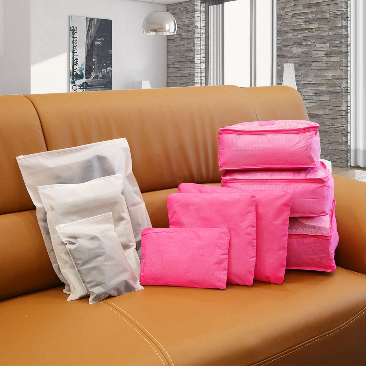 Set of four 9Pcs Clothes Storage Bags Water-Resistant Travel Luggage Organizer Clothing Packing Cubes of varying sizes with clothing items, displayed next to a folded floral blouse, all on a white background.