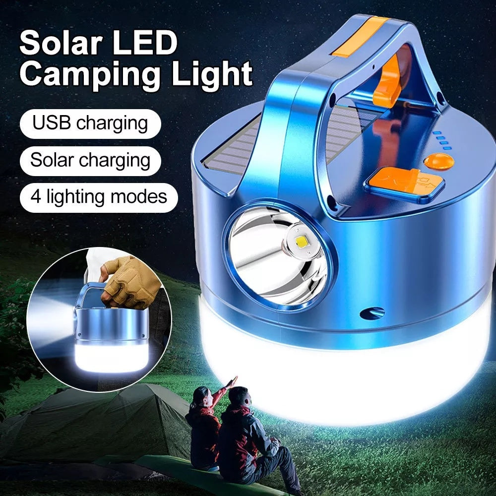A blue 3N1 Solar Lantern With Remote hanging from a tree branch in a forest setting, ideal for outdoor adventures.