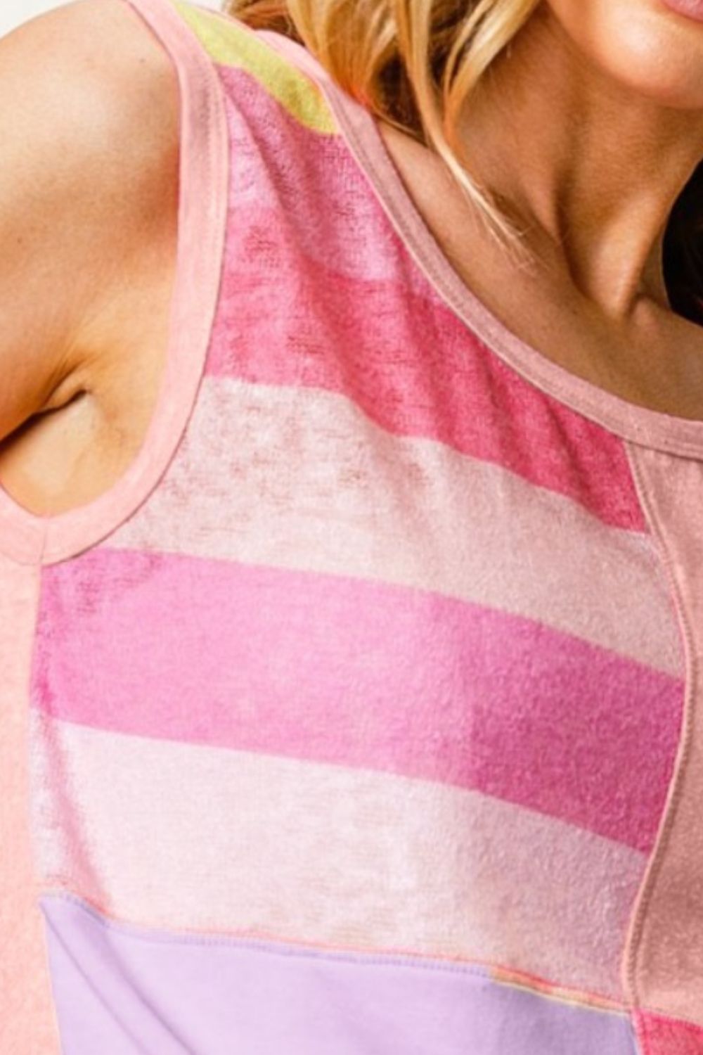 A woman wearing the BiBi Color Block & Striped Round Neck Tank, featuring pink and purple blocks, gazes downward.