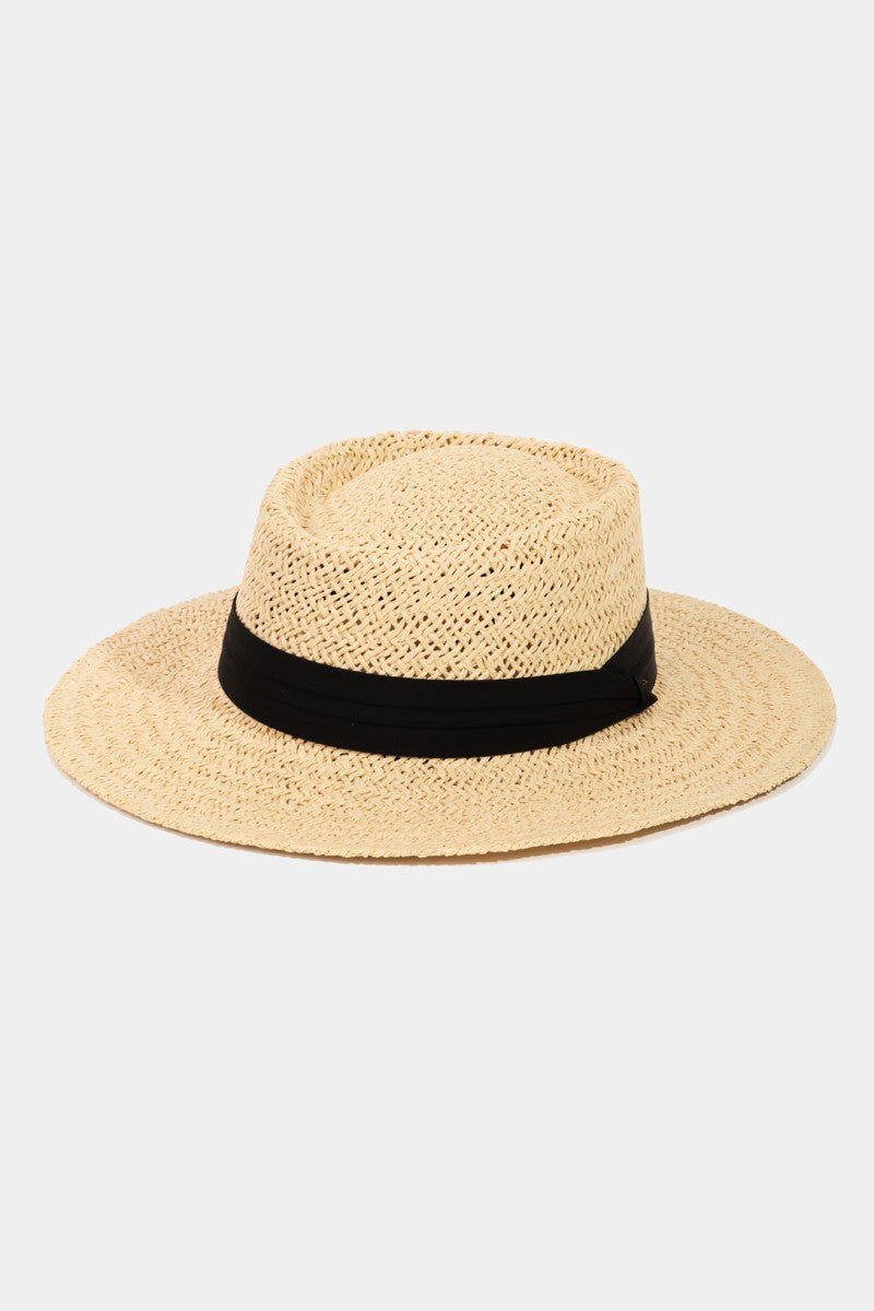 The Fame Straw Braided Pork Pie Hat features a wide brim and a black band around the base, making it the perfect versatile accessory to add summer charm to any outfit.