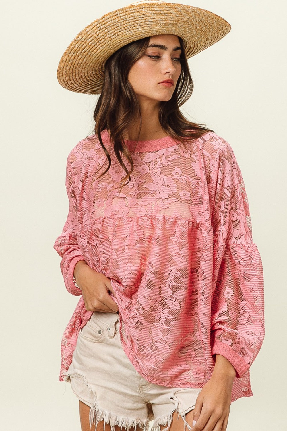 A woman wearing a straw hat, the BiBi Floral Lace Long Sleeve Top, and frayed denim shorts stands against a plain background.