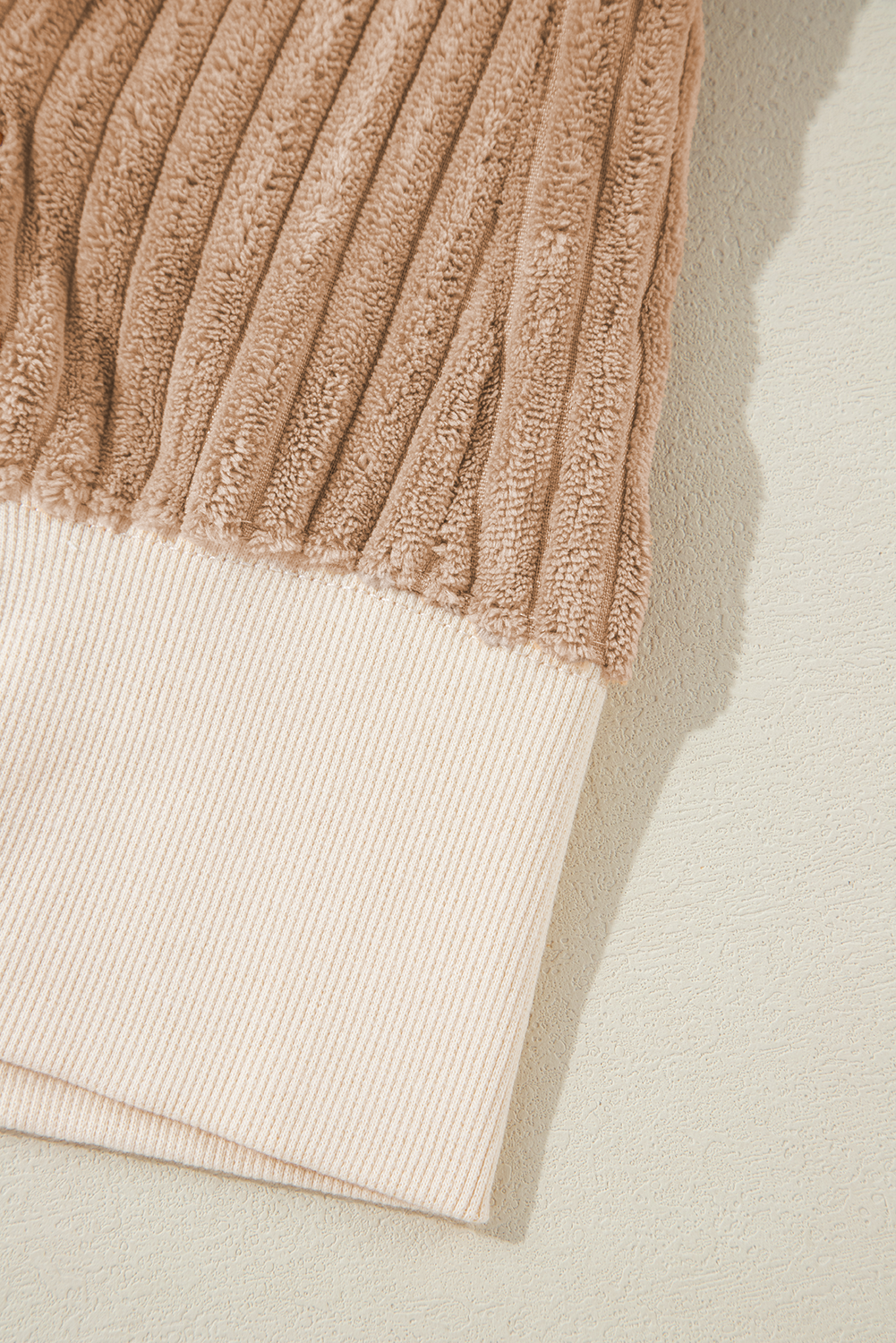 A person with long hair is wearing an Apricot Corduroy Patchwork Drop Shoulder Long Sleeve Sweatshirt, standing with their back to the camera against a light blue corrugated metal wall.