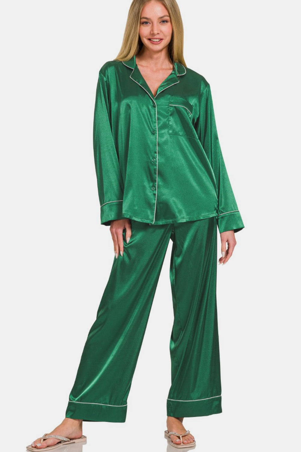 A woman stands against a white background, wearing the Zenana Satin Long Sleeve Shirt and Pants Pajama Set in green.