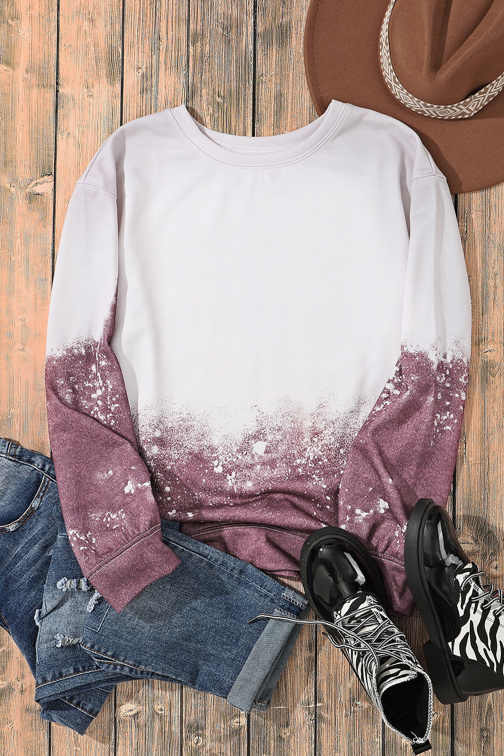 A person with long blonde hair is standing outdoors, facing away from the camera, wearing a Tie Dye Gradient Pullover Sweatshirt featuring a white and brown ombre splatter design.