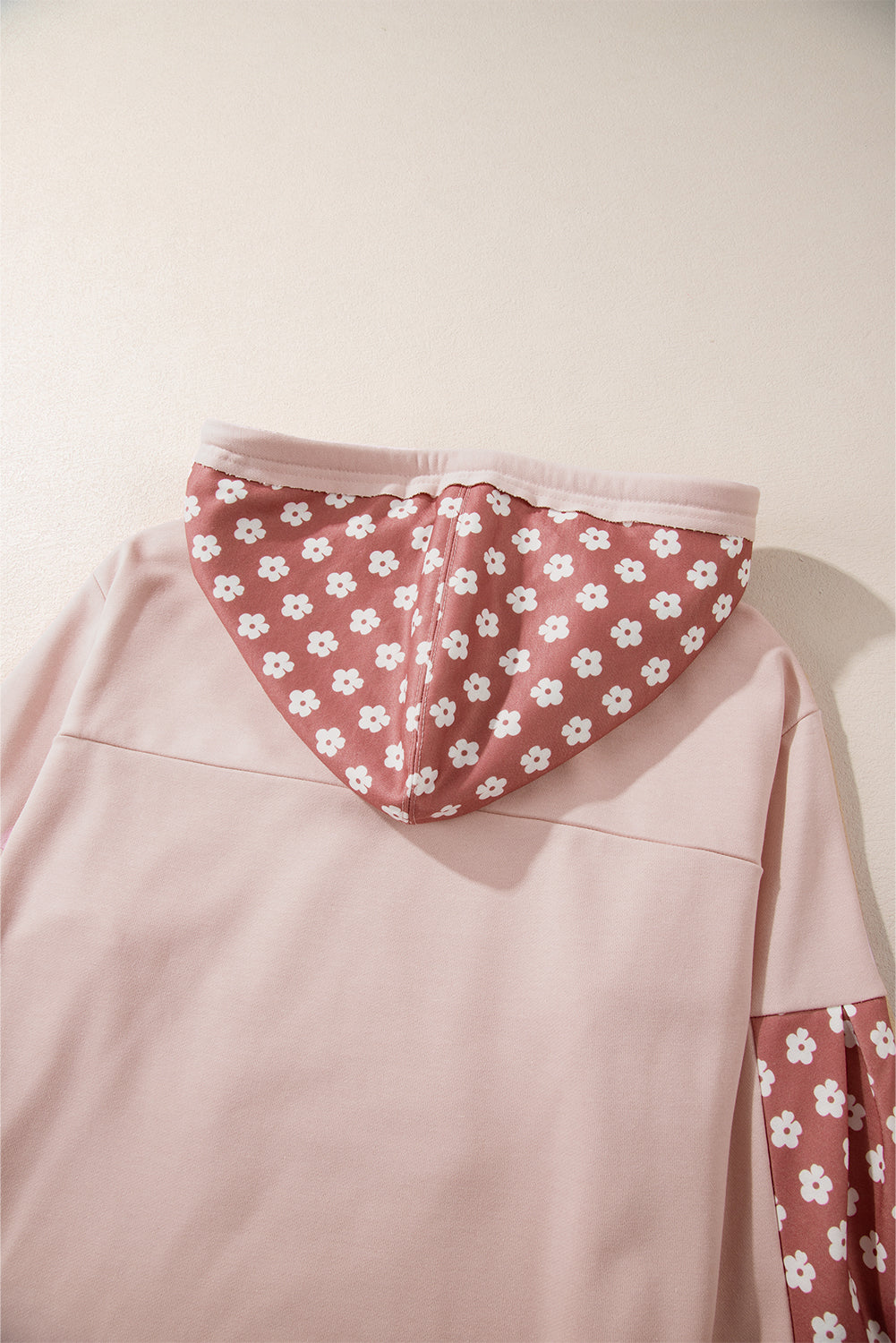 Person wearing the Delicacy Floral Patchwork Star Pattern Drawstring Hoodie, showcasing the floral patchwork design on the hood and sleeves from the back.