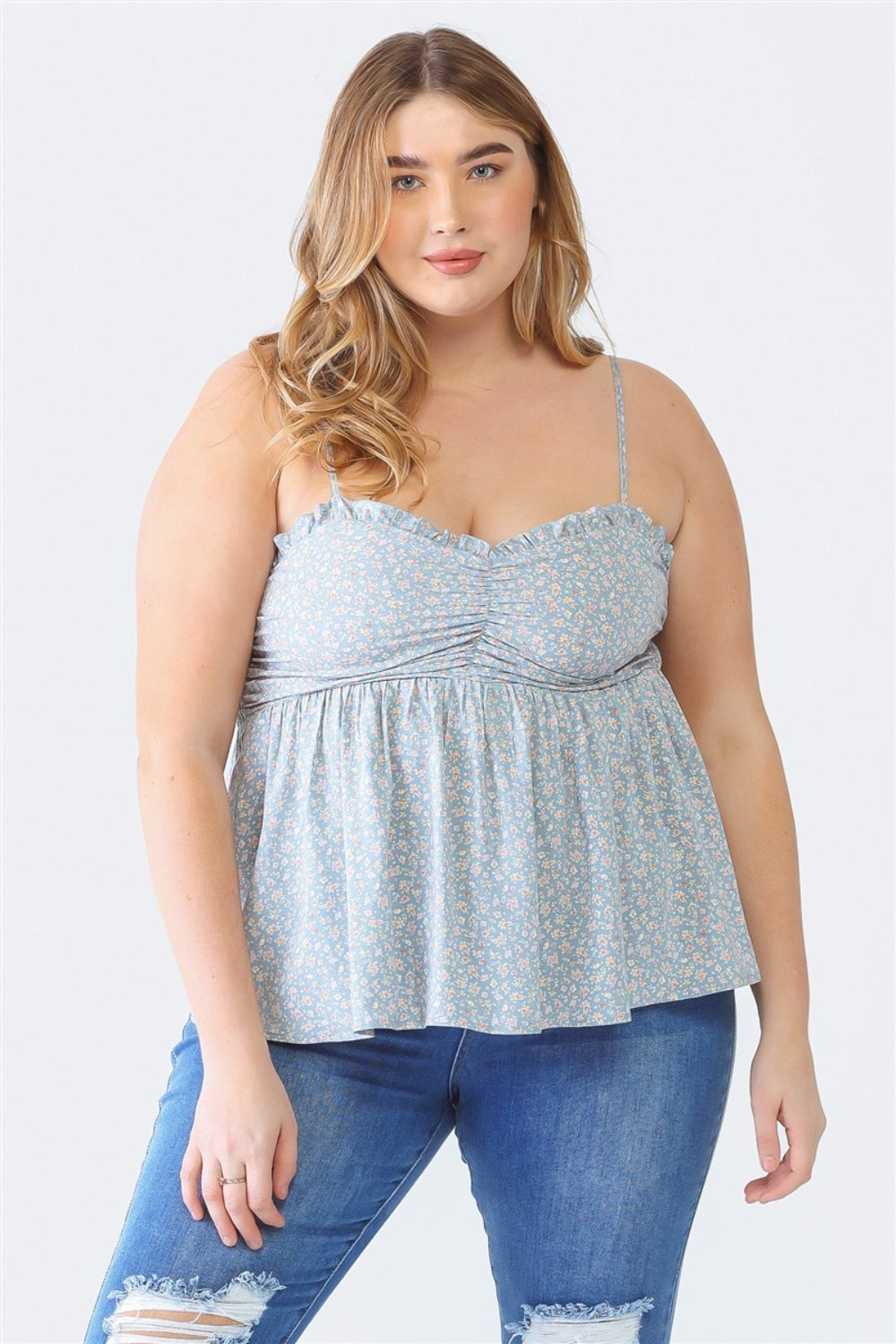 A woman stands facing the camera wearing a Zenobia Plus Size Frill Smocked Floral Sweetheart Neck Cami with dark jeans, against a plain background.