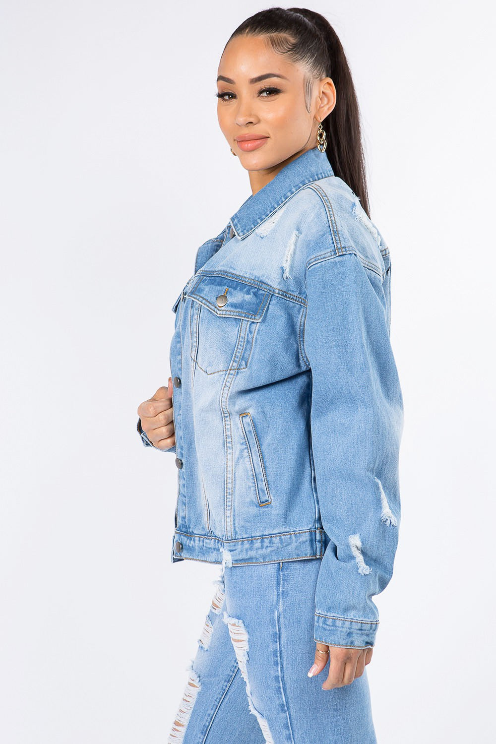 A person wearing the American Bazi Graphic Distressed Long Sleeve Denim Jacket and matching ripped jeans over a white top, standing against a plain white background.