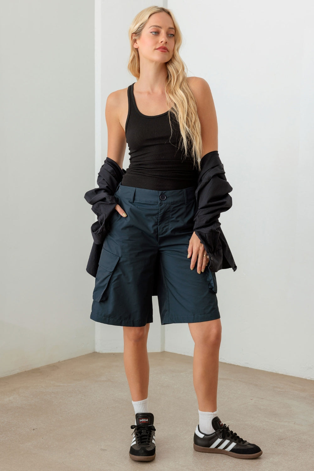 Person wearing a black sleeveless top and Le Lis Navy Cargo Bermuda Shorts with pockets, perfect for a warm-weather wardrobe.