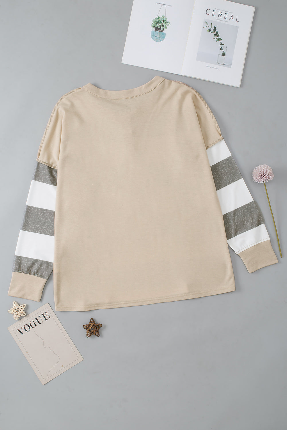 A person wearing a Multicolor Striped Colorblock Patchwork Sweatshirt paired with distressed blue jeans.