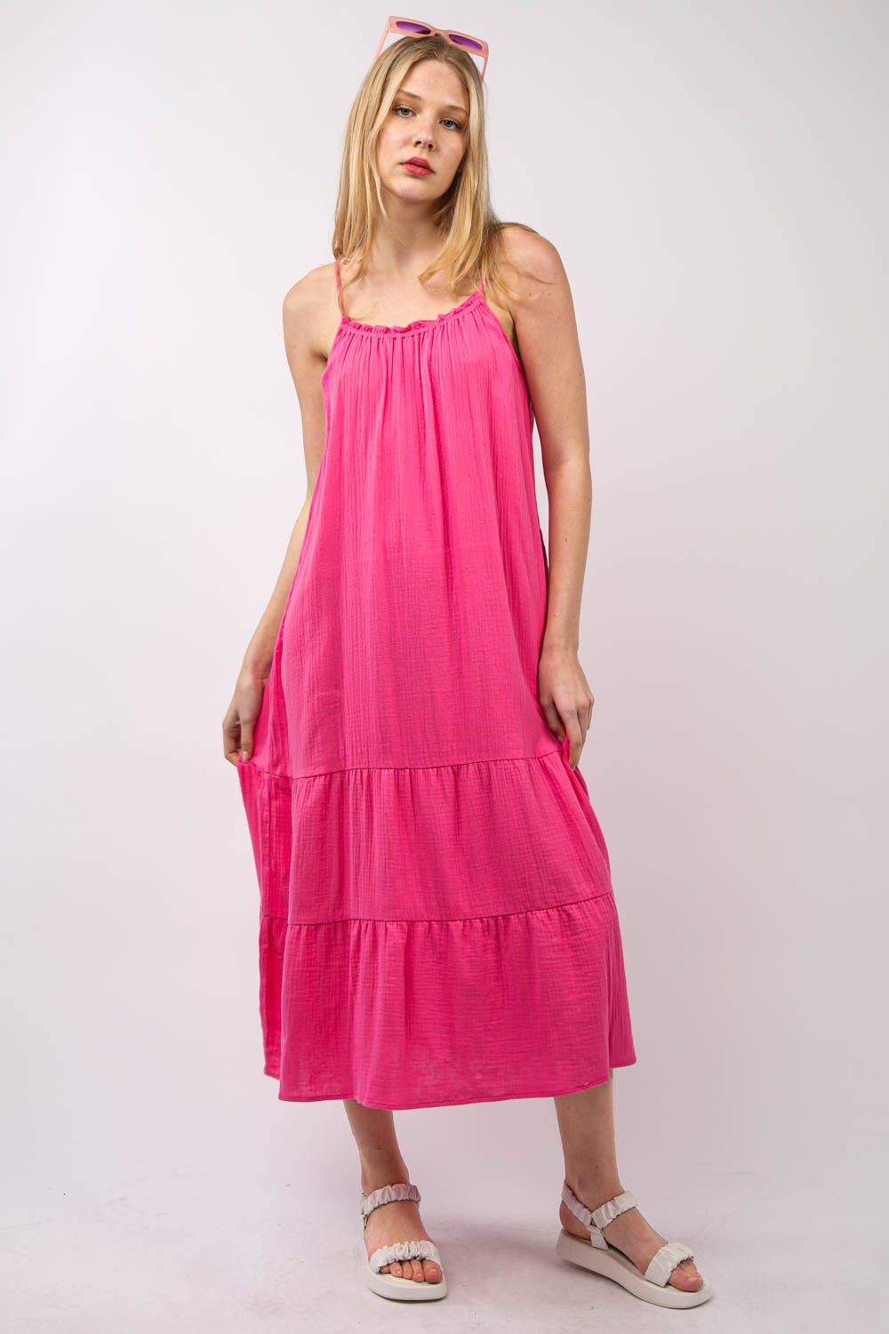 A person with long blonde hair is wearing a bright pink, VERY J Ruffled A-Line Midi Cami Dress and white sandals, standing against a plain background.