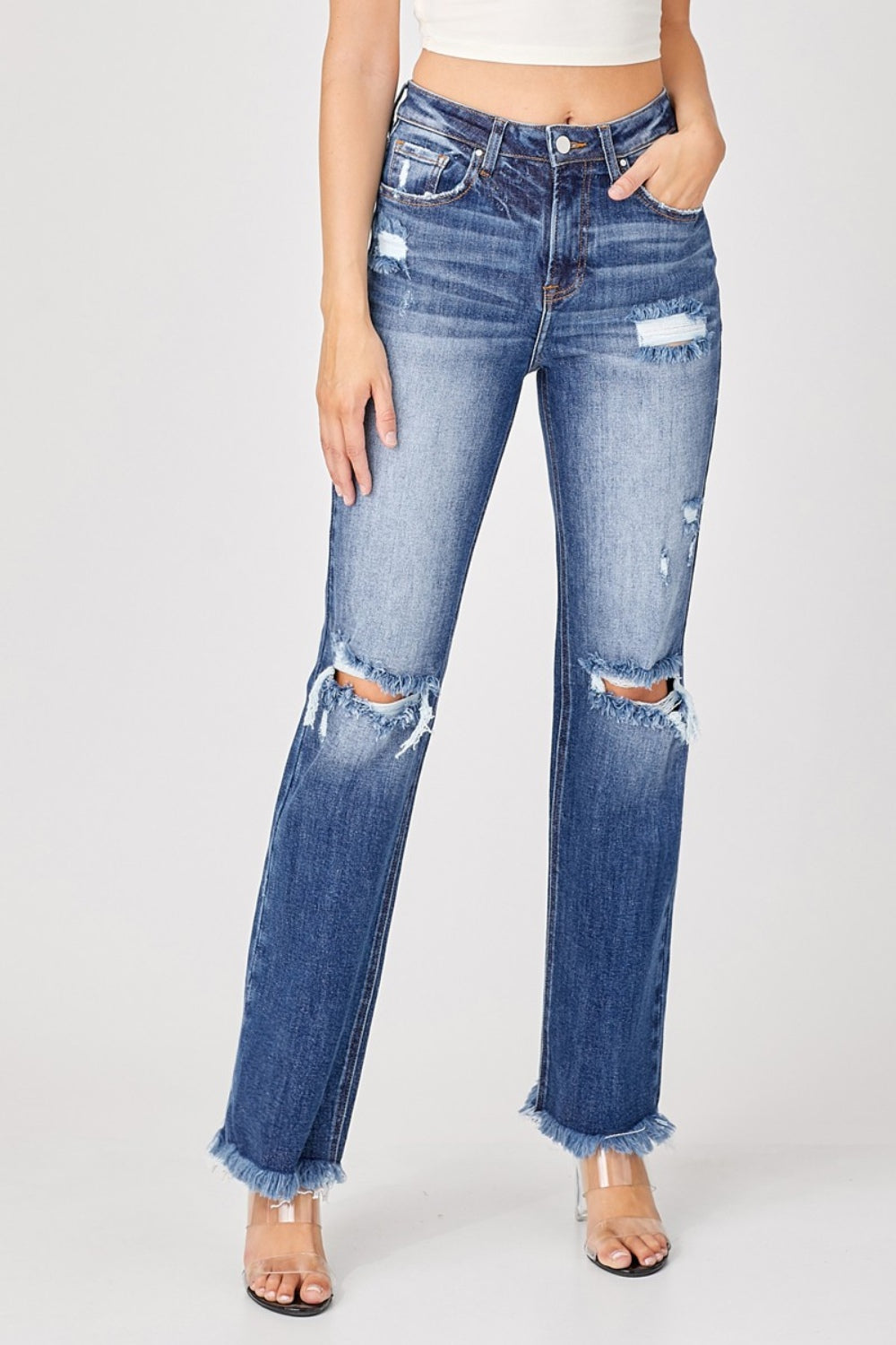 A person is wearing the Risen Full Size Raw Hem Distressed Straight Jeans paired with clear heels.