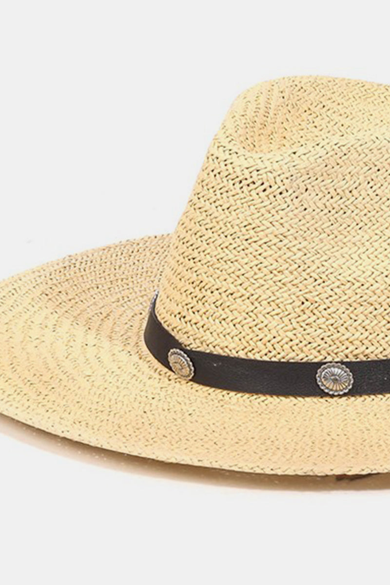 Introducing the Fame Belt Strap Straw Hat, a stylish accessory with a wide brim accented by a black band and decorative silver buttons, ideal for enhancing your summer wardrobe on a plain white background.