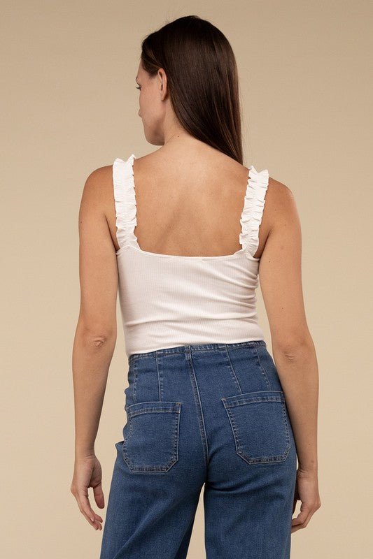 A young woman in a chic Ribbed Ruffle Strap Bodysuit and ripped denim shorts poses against a plain background.