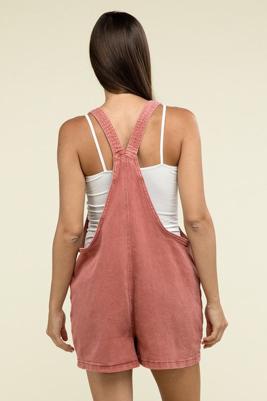 A person wearing the Washed Knot Strap Romper and a white tank top stands against a plain background.