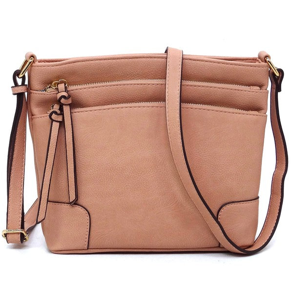 The Fashion Multi Zip Pocket Crossbody Bag is a beige faux leather handbag featuring gold hardware, a front zipper pocket, a two-tone adjustable shoulder strap, and two tassels.