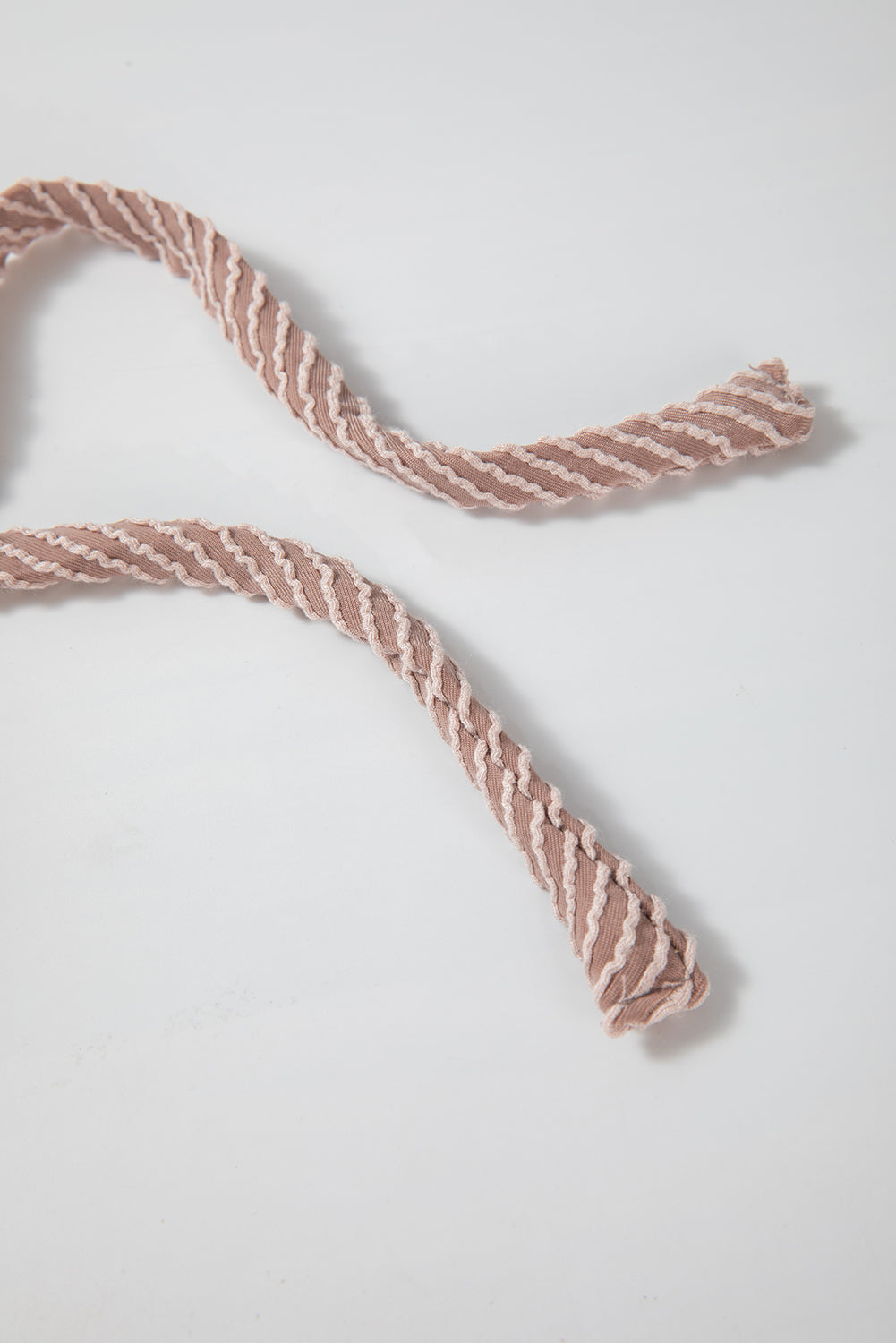 A person with long, wavy hair is facing away from the camera. They are wearing a Dark Brown Flap Pocket Patchwork Corded Drawstring Hoodie and blue jeans, holding a brown shoulder bag.