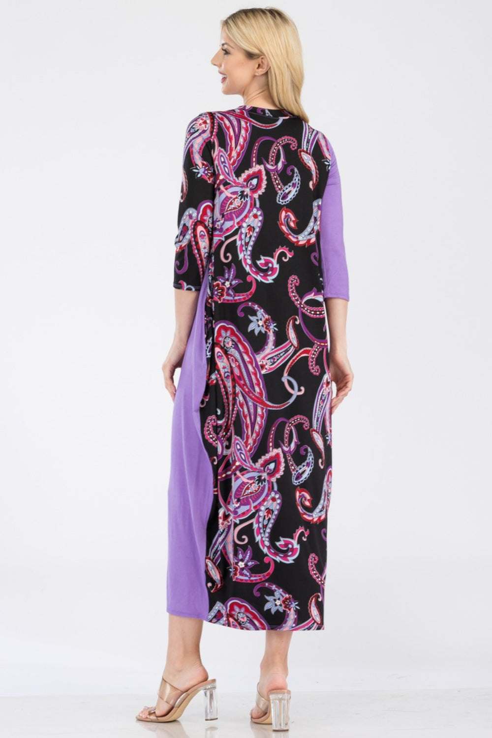 A woman wearing the Celeste Full Size Paisley Contrast Midi Dress with pockets, showcasing a versatile purple and black paisley print, button front detail, and long sleeves.