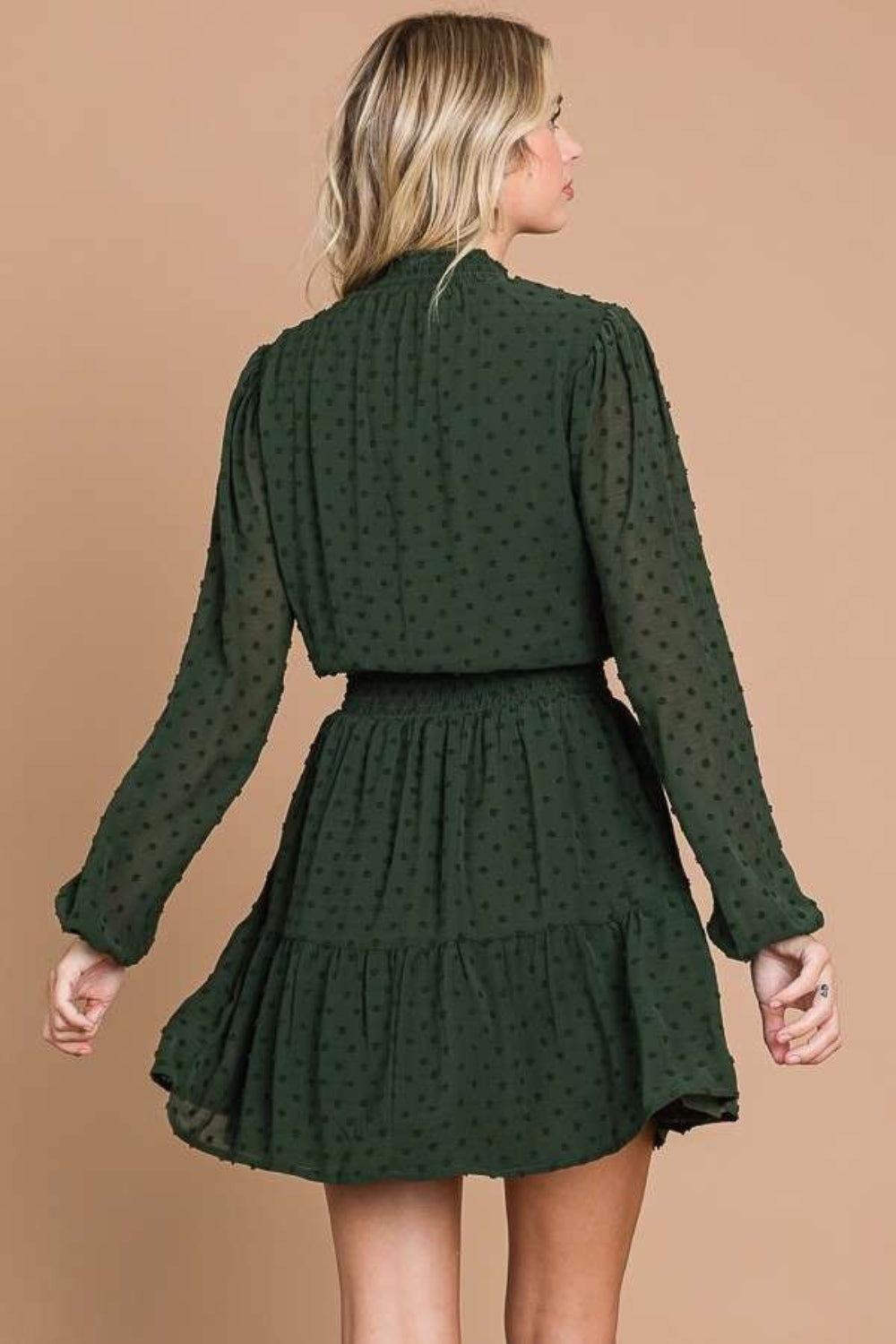 Draped gracefully, a woman wears the Culture Code Swiss Dot Smock Neck Mini Dress with Pockets in green crinkle chiffon.