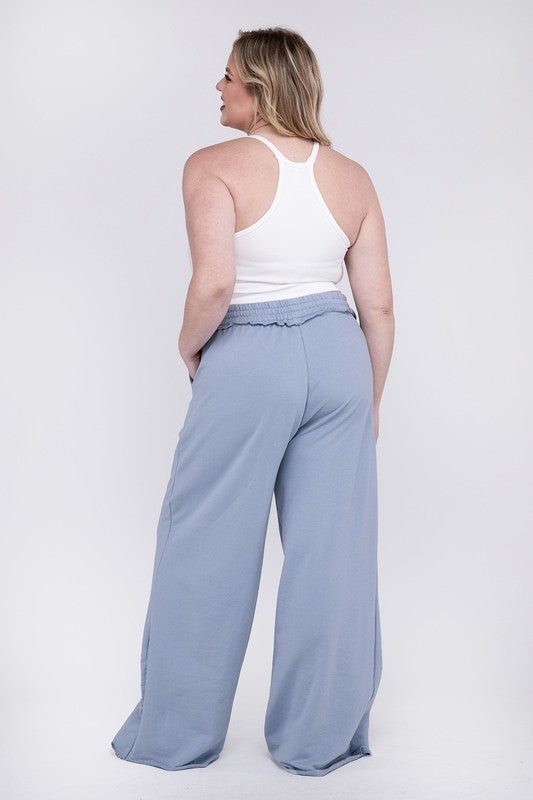 A person wearing the Plus F/Terry Drawstring Waist Raw Edge Hem Pants in pink, paired with white shoes, stands against a plain background.