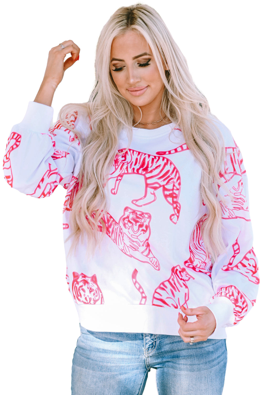 A person with long blonde hair wears a trendy Bright White Pink Animal Print Pullover Sweatshirt, paired with blue jeans, standing outdoors with their back facing the camera.