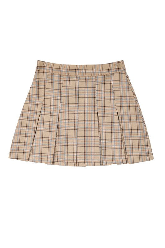 A person dressed in a plaid pleated mini skirt paired with a beige sweater is posed against a plain backdrop. This fashionable and versatile outfit, featuring the Plaid Pleated Mini Skirt, is designed for easy maintenance and can be machine washed in cold water.