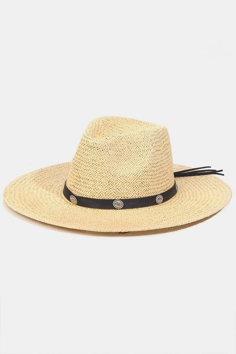 Introducing the Fame Belt Strap Straw Hat, a stylish accessory with a wide brim accented by a black band and decorative silver buttons, ideal for enhancing your summer wardrobe on a plain white background.