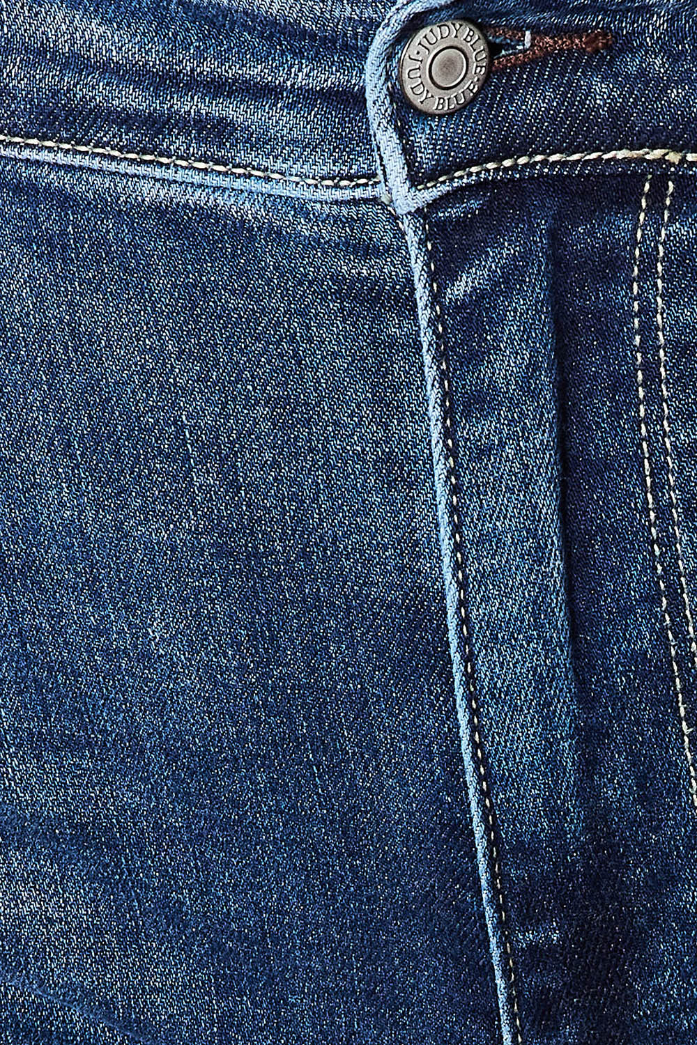 A person wearing Judy Blue Full Size Mid Rise Hand Sand & Destroy Bootcut Jeans stands with hands in pockets. The slightly stretchy jeans have rips on both legs, and the person is standing indoors beside a white dresser.