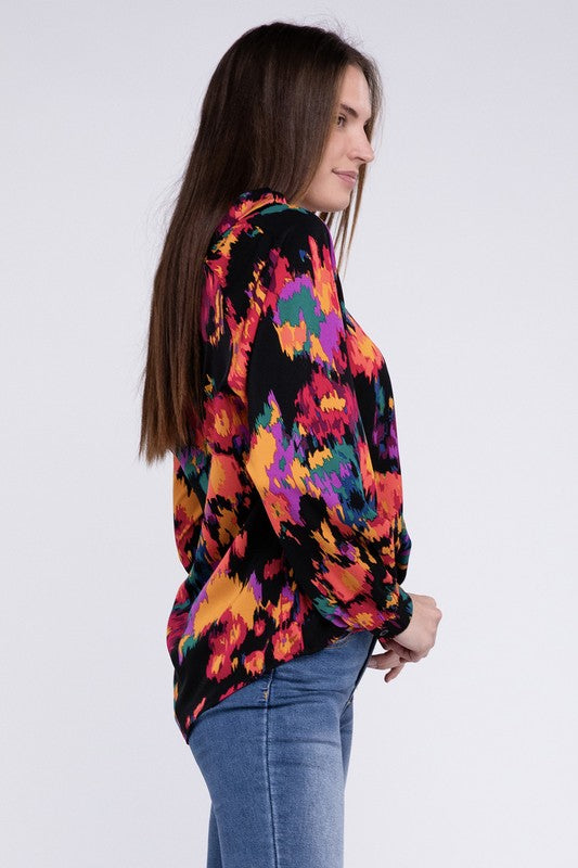 A person dressed in a vibrant Floral Raglan Sleeve Blouse featuring a V-neck stands against a plain backdrop, paired with jeans.