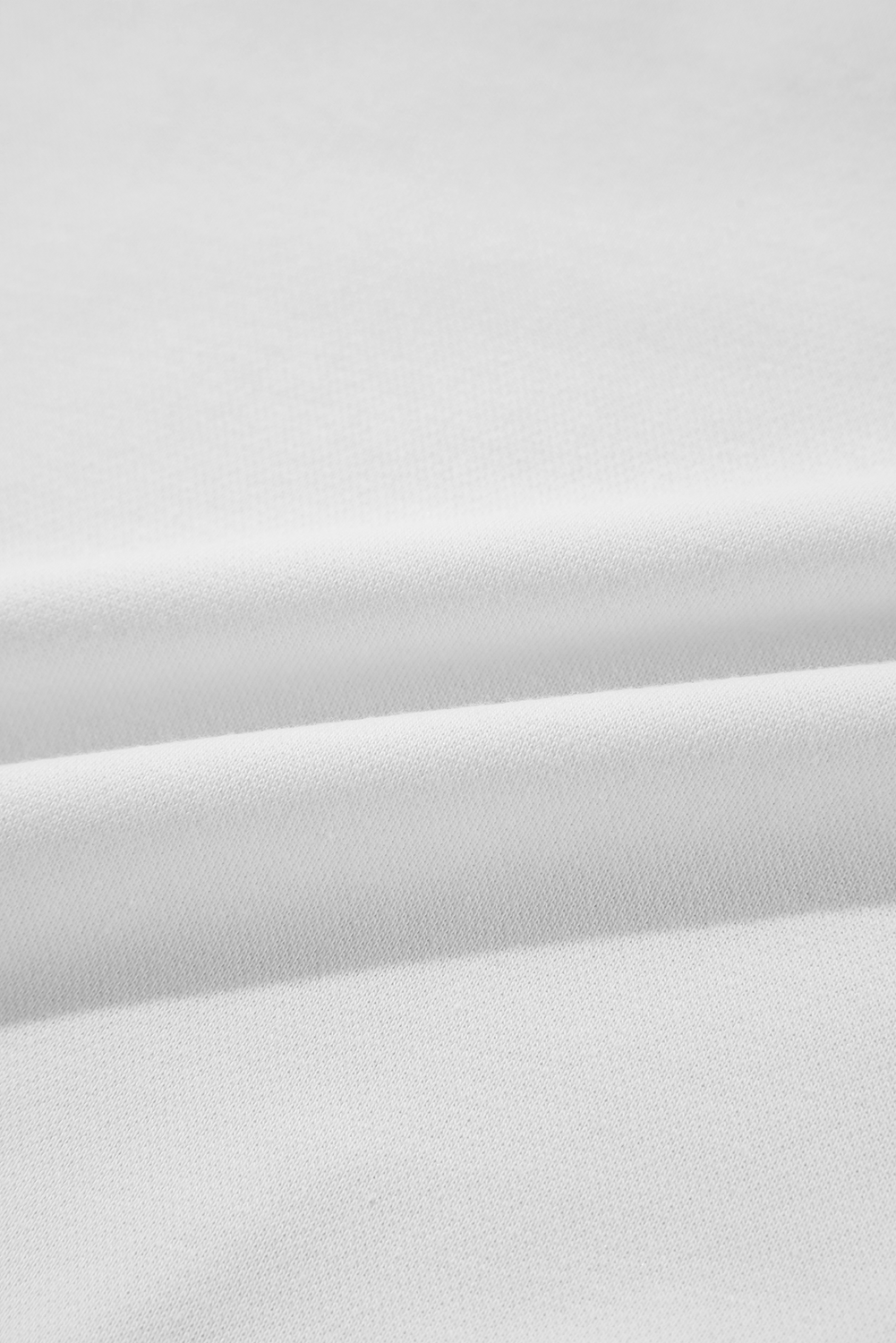 A person with long blonde hair is wearing a White BIRTHDAY QUEEN Graphic Balloon Sleeve Sweatshirt, paired with a pink feathered skirt, and sitting against a beautifully decorated backdrop.