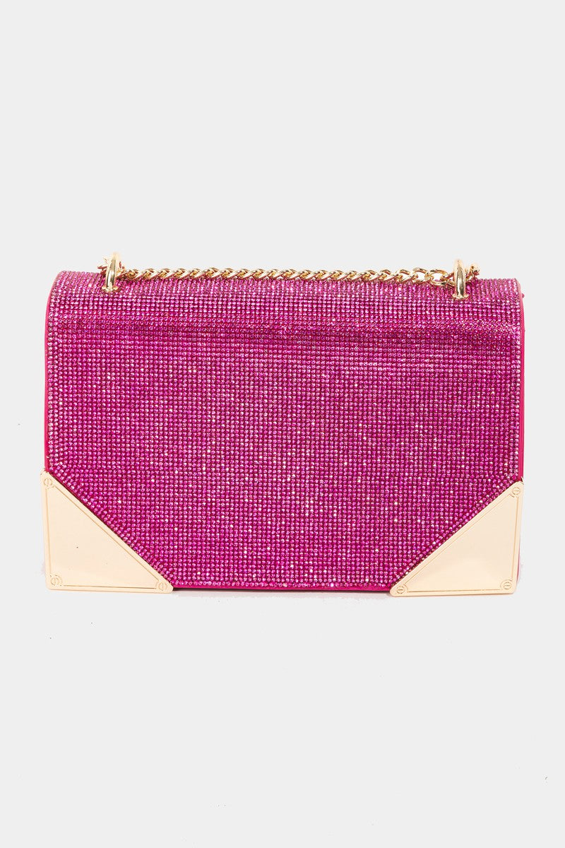 The Fame Rhinestone Studded Rectangle Crossbody Bag is a glamorous pink shoulder bag featuring a gold chain strap and metal corners, making it the perfect medium PU bag to add a touch of elegance to any outfit.