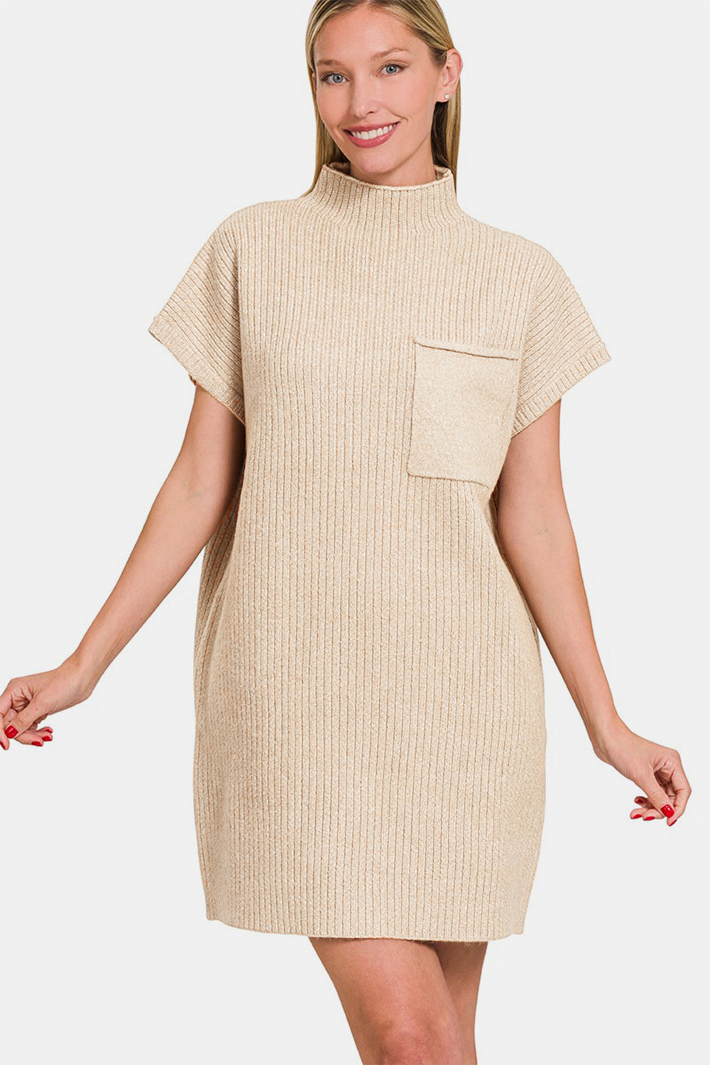 A woman is posing against a white background while wearing the Zenana Short Sleeve Sweater Mini Dress, a beige, ribbed mini dress with short sleeves and a high neck. It features a front pocket and effortlessly combines style and function.