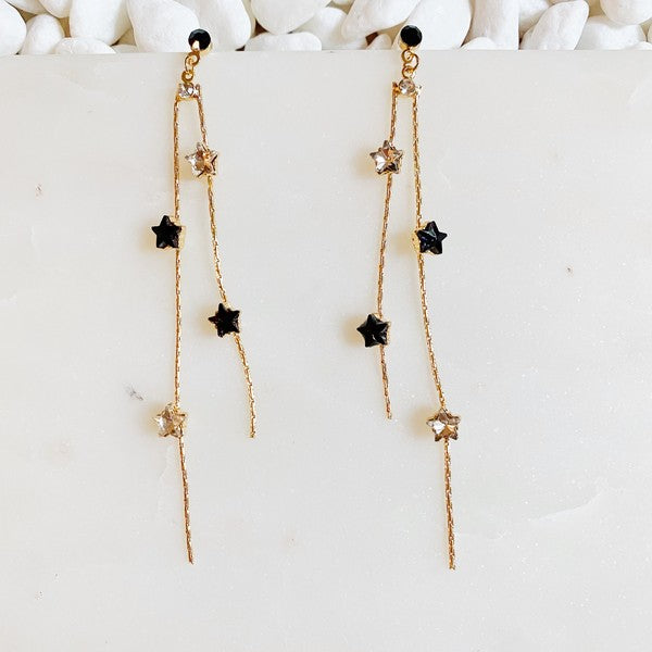 Elegant gold-plated Strands of Stars Earrings on a display stand, perfect for festive parties.