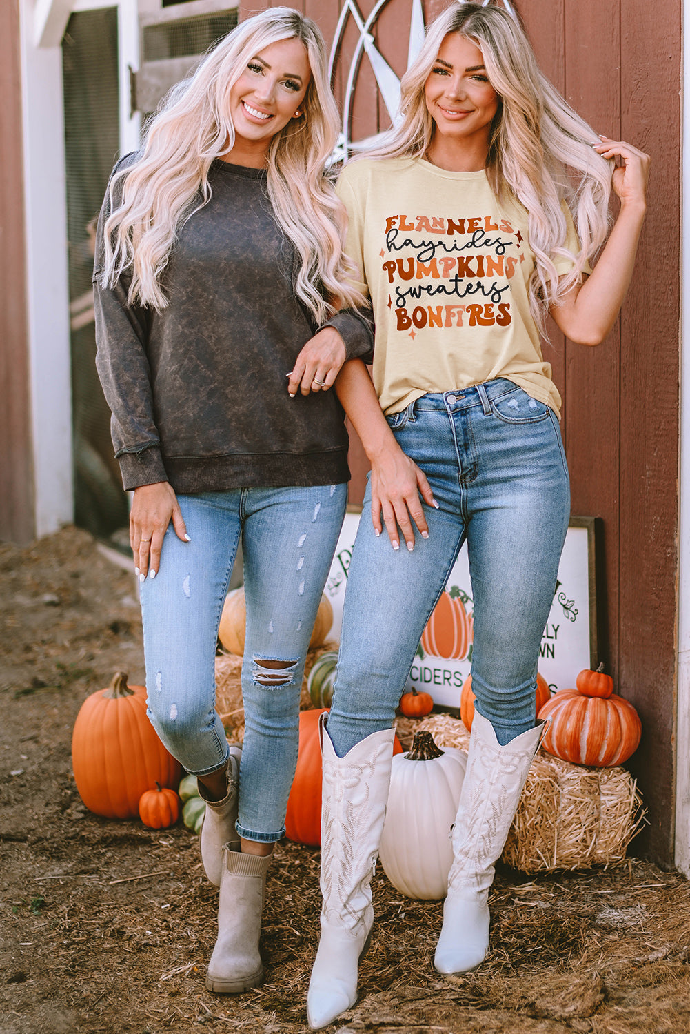 A person with long blonde hair stands with their back to the camera, wearing a Gray Acid Wash Drop Shoulder Long Sleeve Sweatshirt with Pockets and jeans. A large star decoration is visible in the background, along with some pumpkins on the ground.