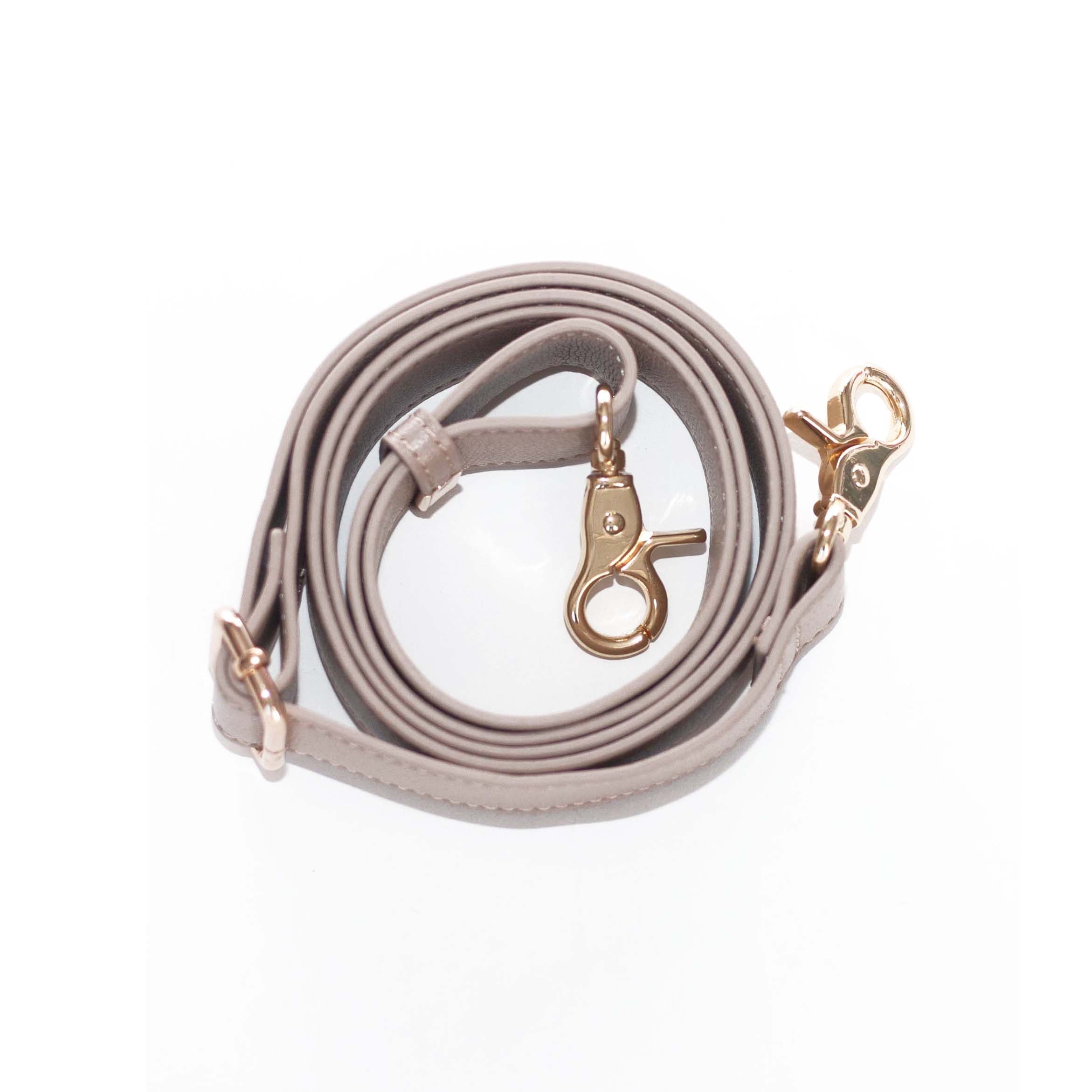 A neat row of four coiled Bag Straps featuring microfiber leather craftsmanship in gray, beige, brown, and black with adjustable gold buckles rests elegantly on a white background. These stylish Elkies accessories add the perfect touch of sophistication to any purse.