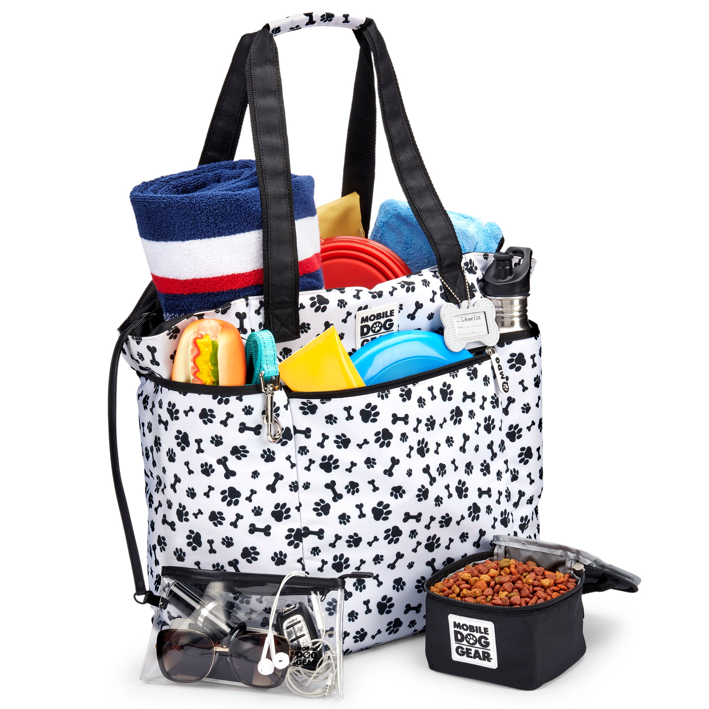 The Mobile Dog Gear Dogssentials Tote Bag features a paw print design, clear pouch, and small accessory bag. Speech bubbles display a dog declaring, "This is MY Bag!" alongside a person exclaiming, "And Mine!" Ideal for stylishly transporting all your dog's essentials.