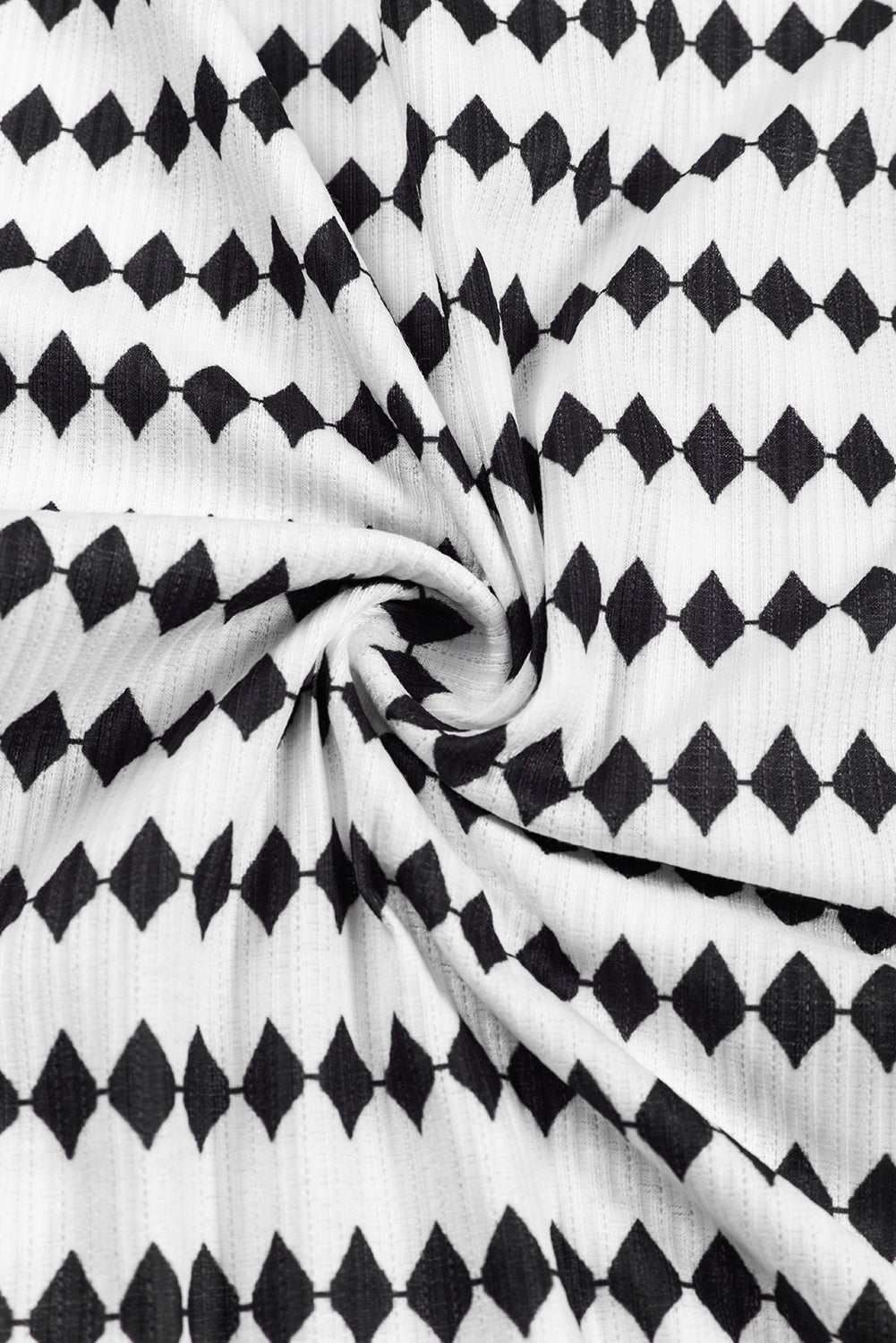 A woman in a Black Stripe Argyle Striped Half Button Oversized Hoodie stands in a room with light green brick walls, a painting of a sailboat, and a fan.