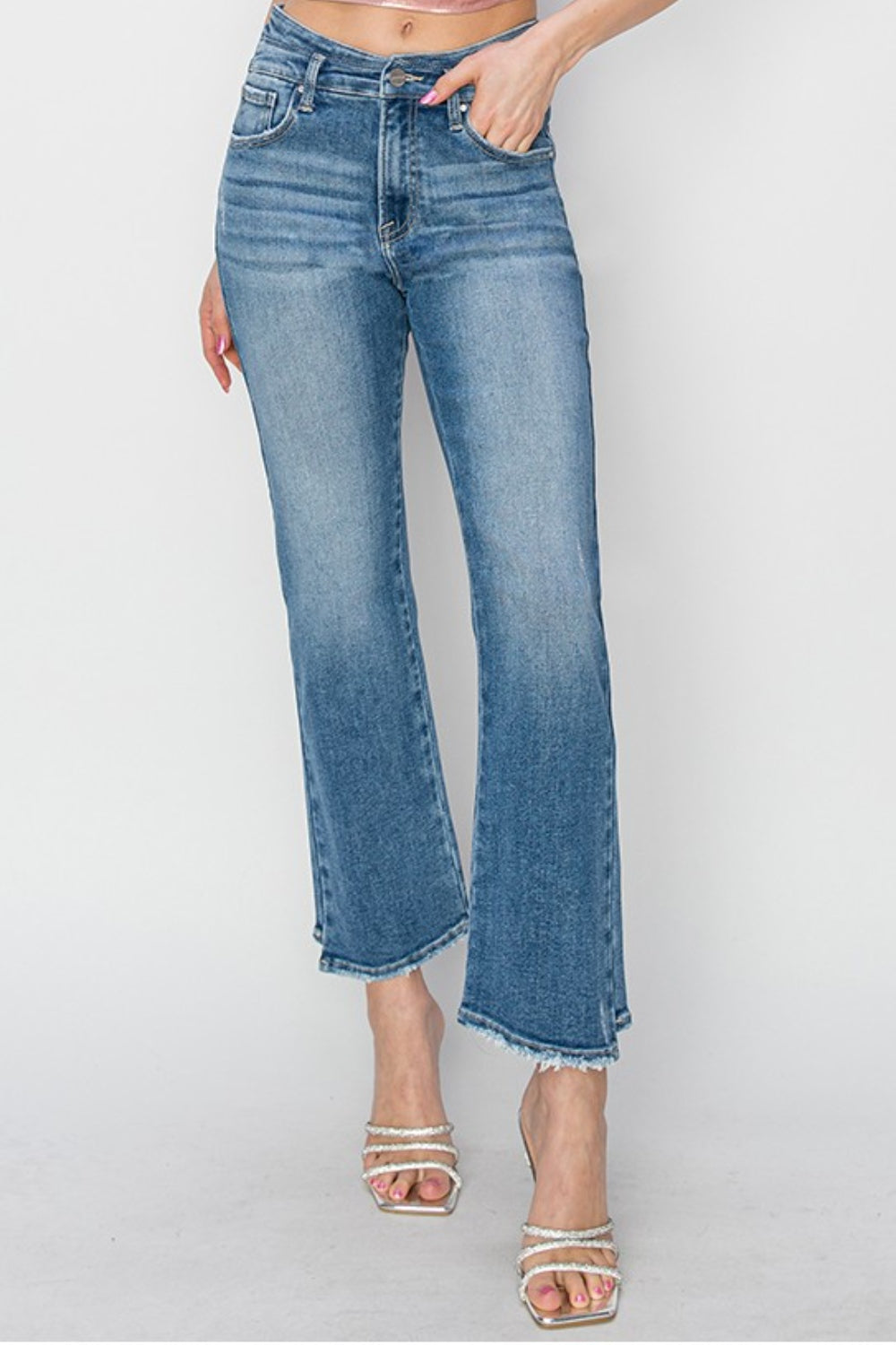 A person wearing RISEN High Rise Slim Straight Jeans with frayed hems and open-toe high-heeled sandals adorned with pearl details, standing against a plain white background.