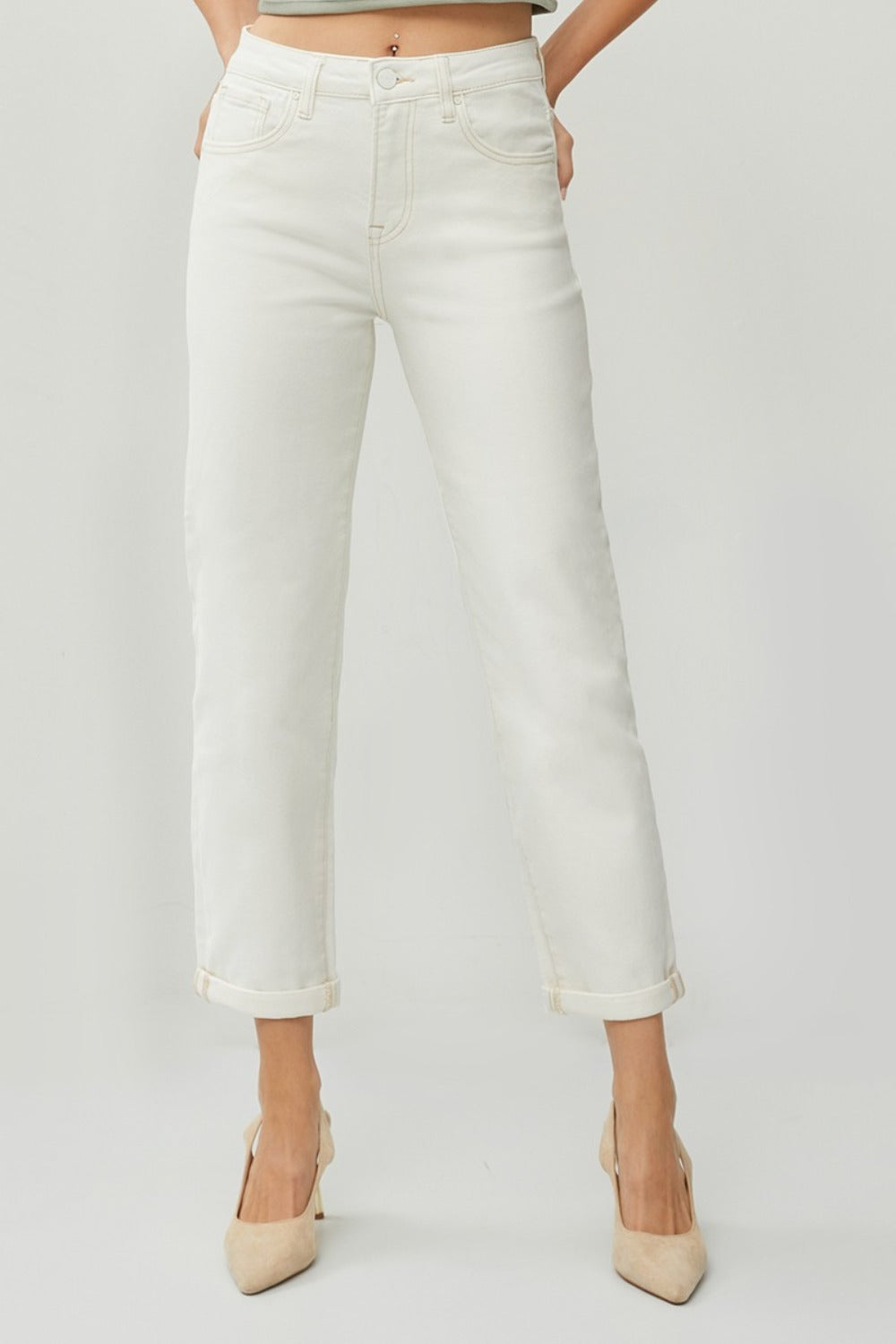 Description: Person wearing RISEN Full Size High Waist Rolled Hem Straight Jeans in white with beige heels against a plain background. 