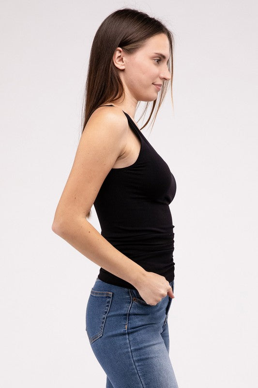 A woman in a white Front & Back 2-Way V-Neck Seamless Tank and black pants, standing with hands on hips and looking at the camera.